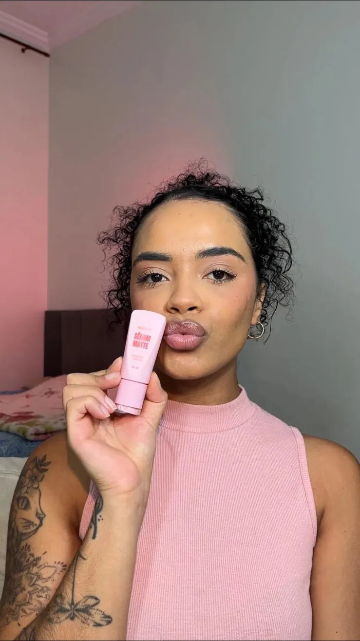 Cliente de blusa rosa mostrando o Sérum Matte Hi Beauty